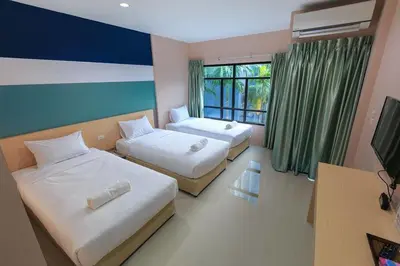 a hotel room with two beds and a television at JJ Residence Phuket Town in Phuket Town