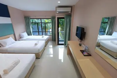 a hotel room with two beds and a flat screen tv at JJ Residence Phuket Town in Phuket Town