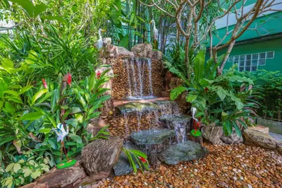 a waterfall in the middle of a garden at Tee Pak Dee Resident Phuket in Phuket Town