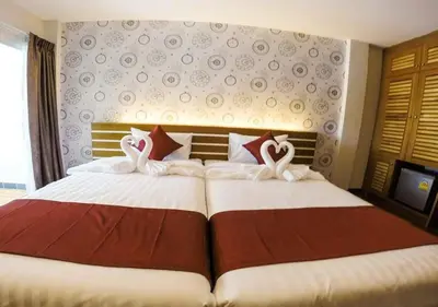 a bedroom with a large bed with two white pillows at Tee Pak Dee Resident Phuket in Phuket Town