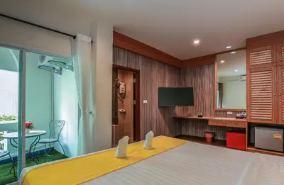a hotel room with a bed and a television at Tee Pak Dee Resident Phuket in Phuket Town