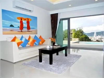 a living room with a white couch and a table at Patong Bay Hill 1 bedroom Apartment in Patong Beach