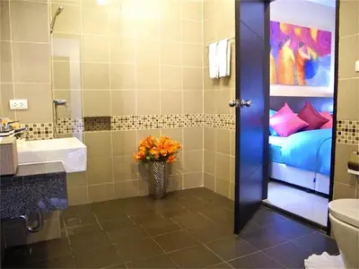 a bathroom with a sink and a vase of flowers at Patong Bay Hill 1 bedroom Apartment in Patong Beach