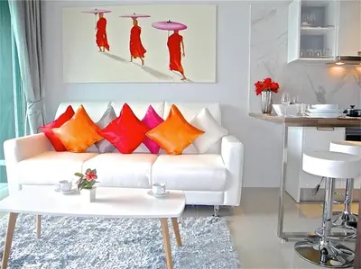 a living room with a white couch and colorful pillows at Emerald Patong 1 bedroom Modern Apartment in Patong Beach