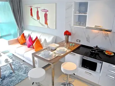 a living room with a white couch and a table at Emerald Patong 1 bedroom Modern Apartment in Patong Beach