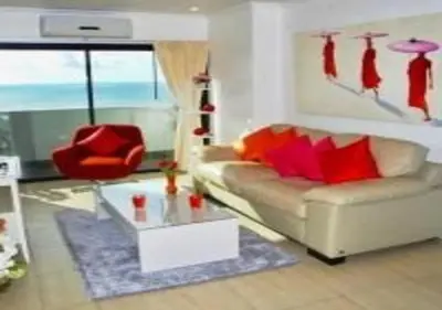 a living room with a couch and a red chair at Patong Tower 1-Bedroom Apartment Full Sea View in Patong Beach