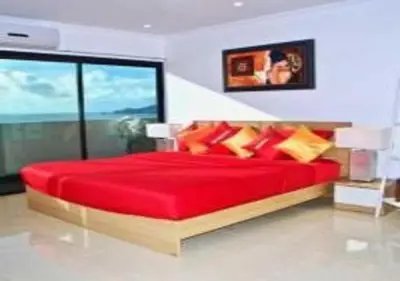 a bedroom with a red bed with a large window at Patong Tower 1-Bedroom Apartment Full Sea View in Patong Beach