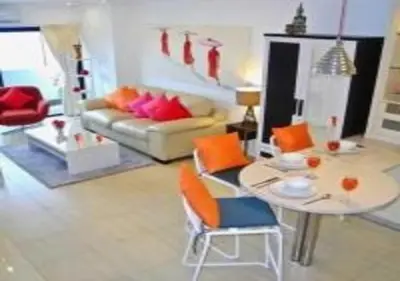 a living room with a table and a couch at Patong Tower 1-Bedroom Apartment Full Sea View in Patong Beach