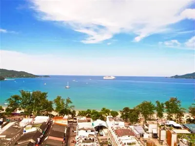 a view of a city and the ocean with a boat at Patong Tower 1-Bedroom Apartment Full Sea View in Patong Beach