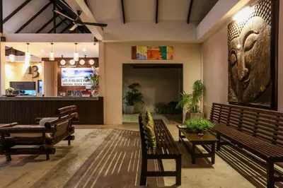 a lobby with two benches and a table at Naiharn Beach Resort - SHA Plus Extra in Nai Harn Beach