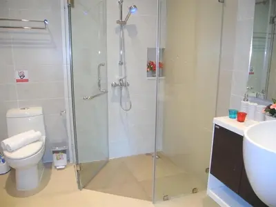 a bathroom with a shower with a toilet and a sink at Emerald Patong 1 bedroom Apartment Garden View in Patong Beach