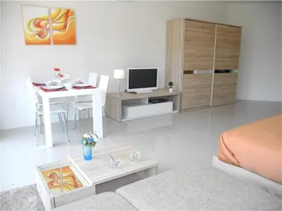 a bedroom with a bed and a desk with a television at Chic Karon Nice Apartment close to Karon Beach in Karon Beach