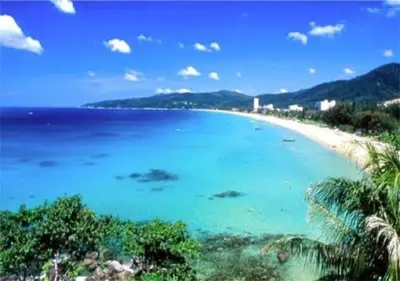a view of a beach with blue water and palm trees at Chic Karon Nice Apartment close to Karon Beach in Karon Beach