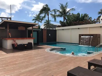 a man sitting in a pool next to a building at Baan Petcharat in Patong Beach