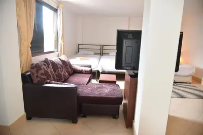 a living room with a couch and a tv at Baan Petcharat in Patong Beach