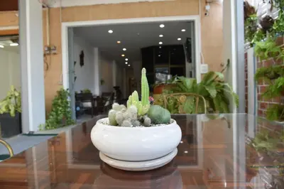 a white vase with cactuses sitting on a table at Baan Petcharat in Patong Beach