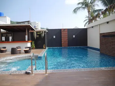 a swimming pool in the middle of a building at Baan Petcharat in Patong Beach