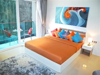 a bedroom with a bed and a painting on the wall at Emerald Patong New Studio with Balcony in Patong Beach