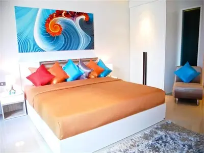 a bedroom with a large bed with colorful pillows at Emerald Patong New Studio with Balcony in Patong Beach