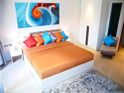 a bedroom with a bed with a painting on the wall at Emerald Patong New Studio with Balcony in Patong Beach