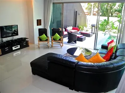 a living room with a black leather couch at Eva Villa Rawai 3 bedrooms Private Pool in Rawai Beach
