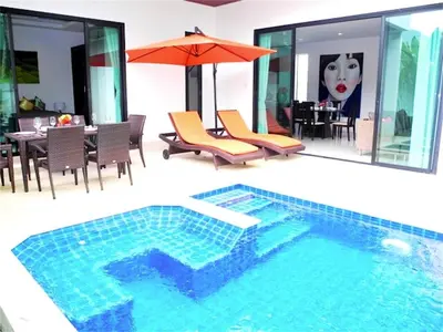 a swimming pool in a house with a table and an umbrella at Intira Villa Rawai 2 bedrooms Villa in Rawai Beach