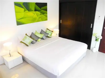 a bedroom with a large white bed with green pillows at Intira Villa Rawai 2 bedrooms Villa in Rawai Beach