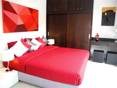 a bedroom with a red bed with a red bedspread at Intira Villa Rawai 2 bedrooms Villa in Rawai Beach