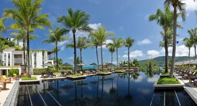 a pool at a resort with chairs and palm trees at Andara Resort Villas in Kamala Beach