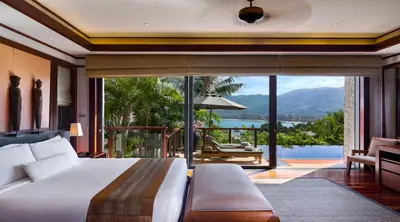a bedroom with a bed and a balcony with a view at Andara Resort Villas in Kamala Beach