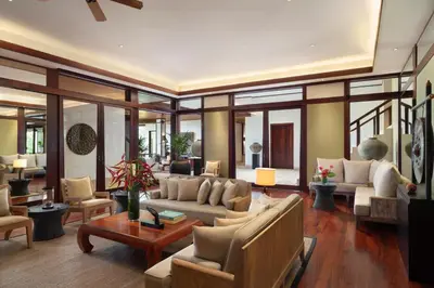 a living room with couches and tables and windows at Andara Resort Villas in Kamala Beach