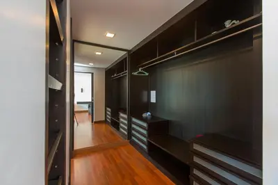 a walk in closet with black cabinets and wood floors at The Palms, Kamala Beach - SHA Extra Plus in Kamala Beach
