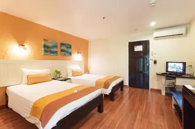 a hotel room with two beds and a television at Vacation Village Phra Nang Inn - SHA Extra Plus in Ao Nang Beach