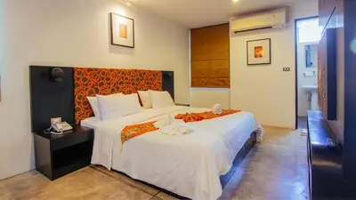 a bedroom with a large bed with an orange headboard at The Yorkshire Hotel - SHA Certified in Patong Beach