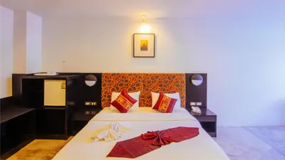 a bedroom with a large bed with red pillows at The Yorkshire Hotel - SHA Certified in Patong Beach
