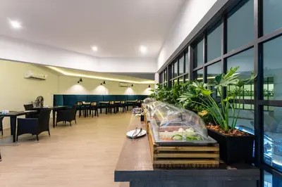 a lobby with tables and chairs and a cafeteria at Coconut Village Resort Phuket - SHA Extra Plus in Patong Beach
