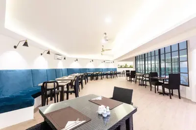 a dining room with tables and chairs and windows at Coconut Village Resort Phuket - SHA Extra Plus in Patong Beach