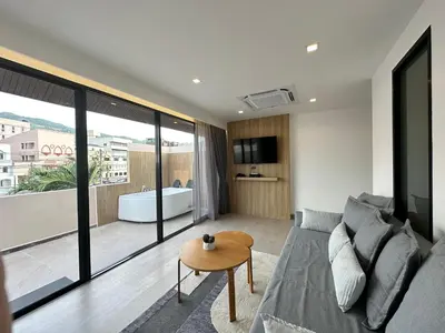 a living room with a couch and a table at Coconut Village Resort Phuket - SHA Extra Plus in Patong Beach
