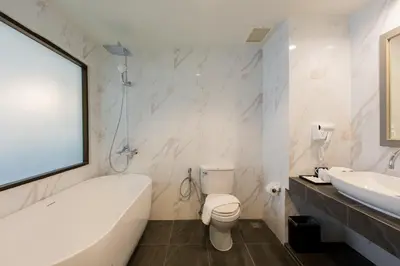 a bathroom with a tub and a toilet and a sink at Coconut Village Resort Phuket - SHA Extra Plus in Patong Beach