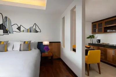 a bedroom with a bed and a table with a yellow chair at Avani Ao Nang Cliff Krabi Resort in Ao Nang Beach