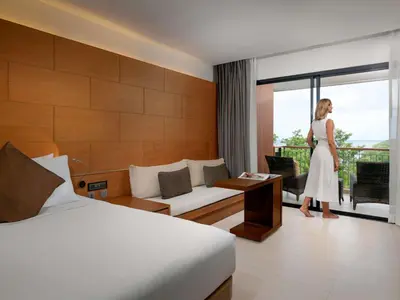 a woman is standing in a hotel room at Novotel Phuket Kata Avista Resort and Spa in Kata Beach