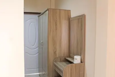 a wooden cabinet in a room with a shelf at Sirikul Mansion in Nai Yang Beach