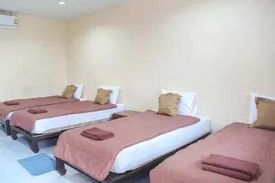 a room with three beds with brown blankets at Sirikul Mansion in Nai Yang Beach