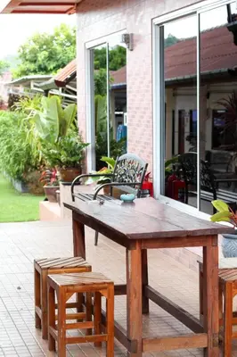 a wooden table and two chairs on a patio at Sirikul Mansion in Nai Yang Beach