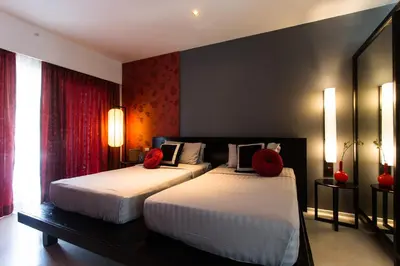 a bedroom with two beds with red pillows on them at Red Ginger Chic Resort in Ao Nang Beach