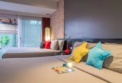 a hotel room with two beds with colorful pillows at Red Ginger Chic Resort in Ao Nang Beach