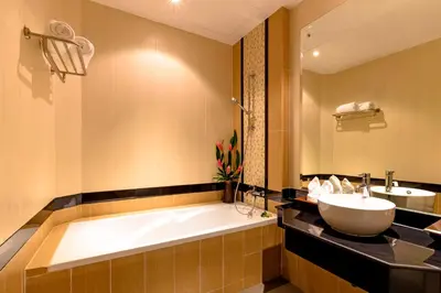 a bathroom with a bath tub and a sink at Nipa Resort, Patong Beach in Patong Beach