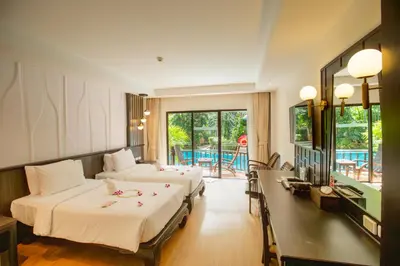 a hotel room with two beds and a balcony at Nipa Resort, Patong Beach in Patong Beach