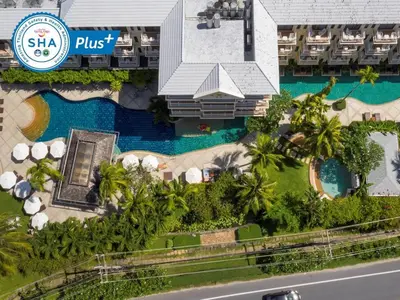 an aerial view of a resort with a swimming pool at The Front Village - SHA Plus in Karon Beach