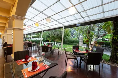 a restaurant with tables and chairs and a large glass ceiling at The Front Village - SHA Plus in Karon Beach